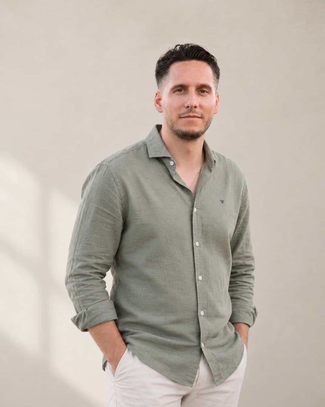 Portrait of Alberto Bort, founder of BPM Tech, wearing a green linen shirt against a light wall